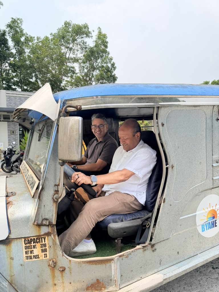 Sohail Hasnie driving a retrofitted electric jeepney in Manila with co-founder Laurence Bahia
